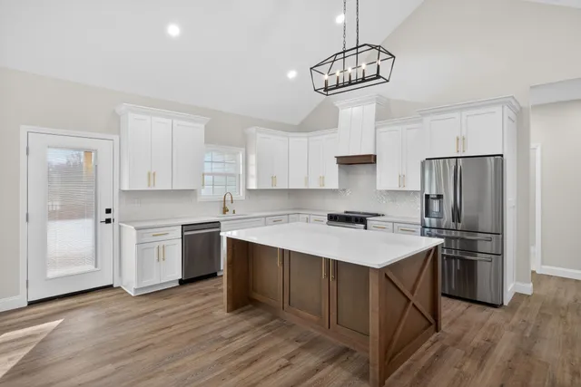 a kitchen with a center island white cabinets and stainless steel appliances
