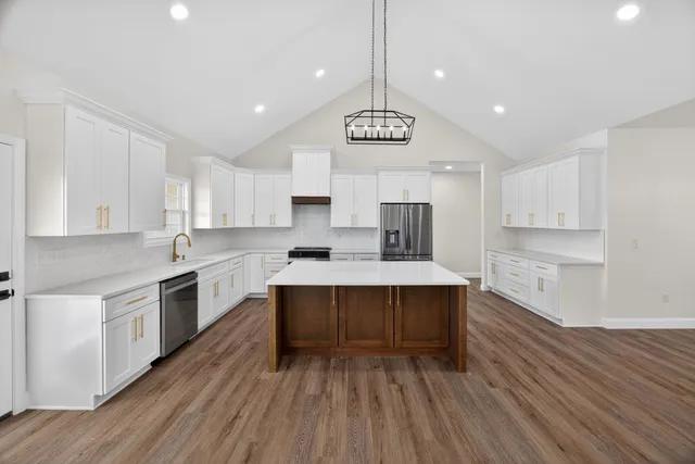 a large kitchen with stainless steel appliances a large center island wooden floor stainless steel appliances and cabinets