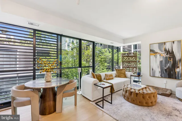 a living room with furniture a flat screen tv and a floor to ceiling window