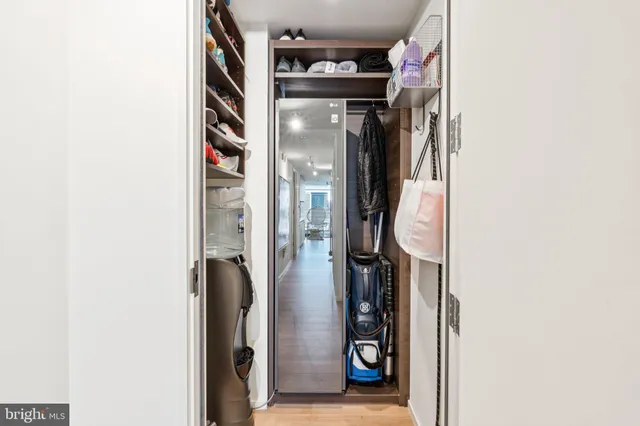 a view of walk in closet with clothes and shoes