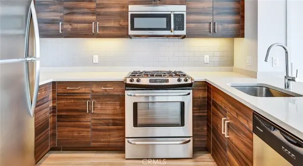 a kitchen with granite countertop a stove top oven microwave and cabinets