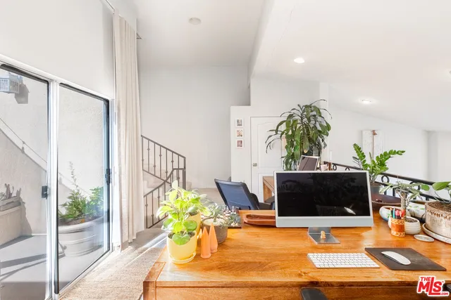 a living room with furniture a flat screen tv and a potted plant