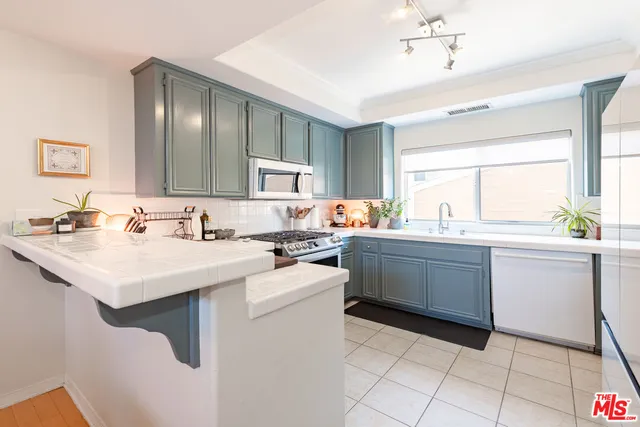 a kitchen with a sink appliances and cabinets