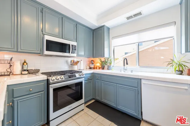 a kitchen with stainless steel appliances a stove sink and microwave