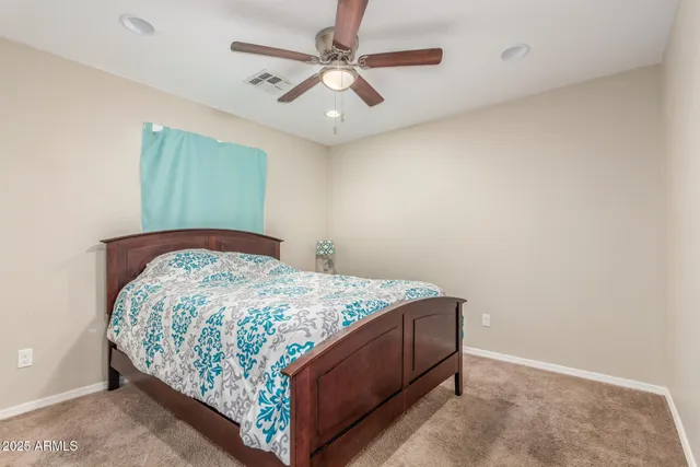 a bedroom with a bed and a ceiling fan