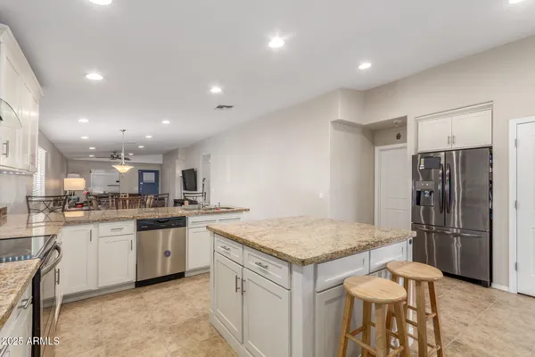 a kitchen with a sink a refrigerator and a stove top oven