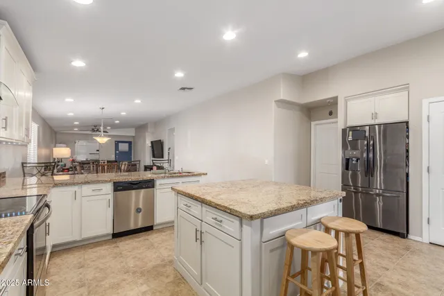 a kitchen with a sink a refrigerator and a stove top oven