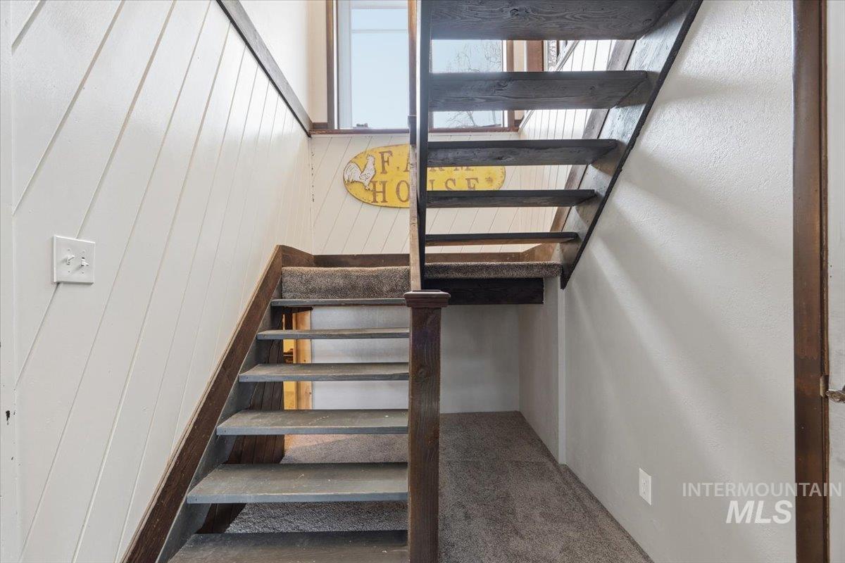 7771 Elmore Road Fruitland, ID 83619 - Photo 18 of 48 Stairs with carpet and wood walls