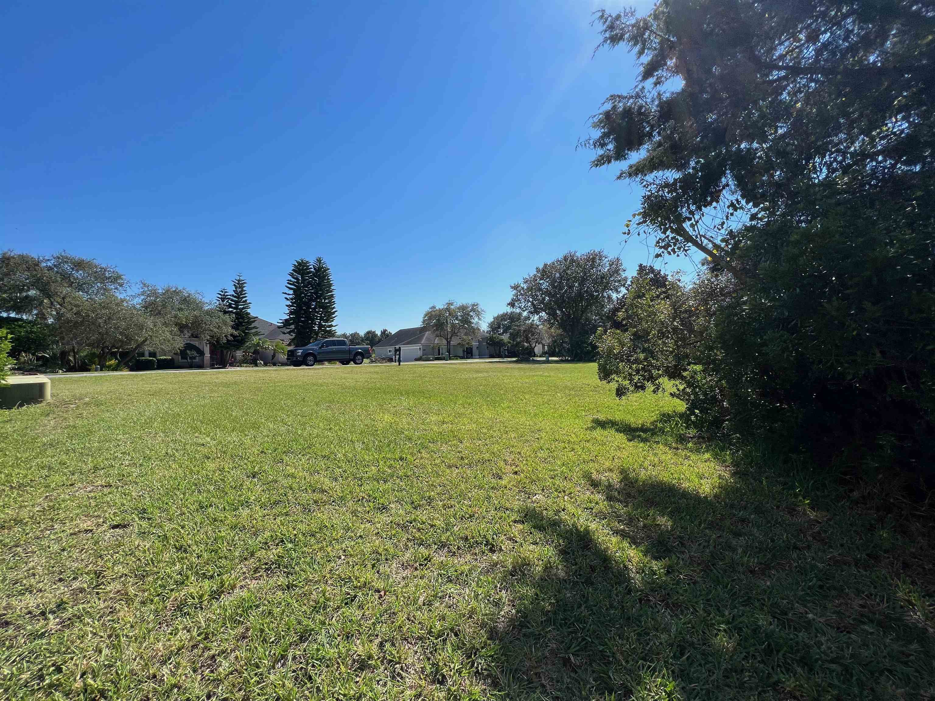 143 Marshside Drive St. Augustine, FL 32080 - Photo 14 of 16 a view of a green field with wooden fence
