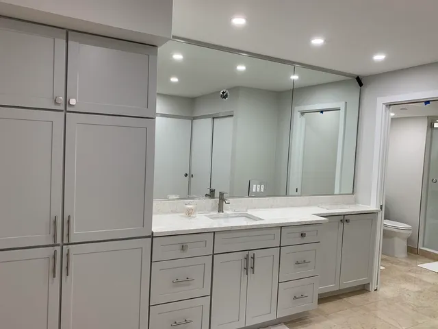 a bathroom with a granite countertop sink mirror and cabinets