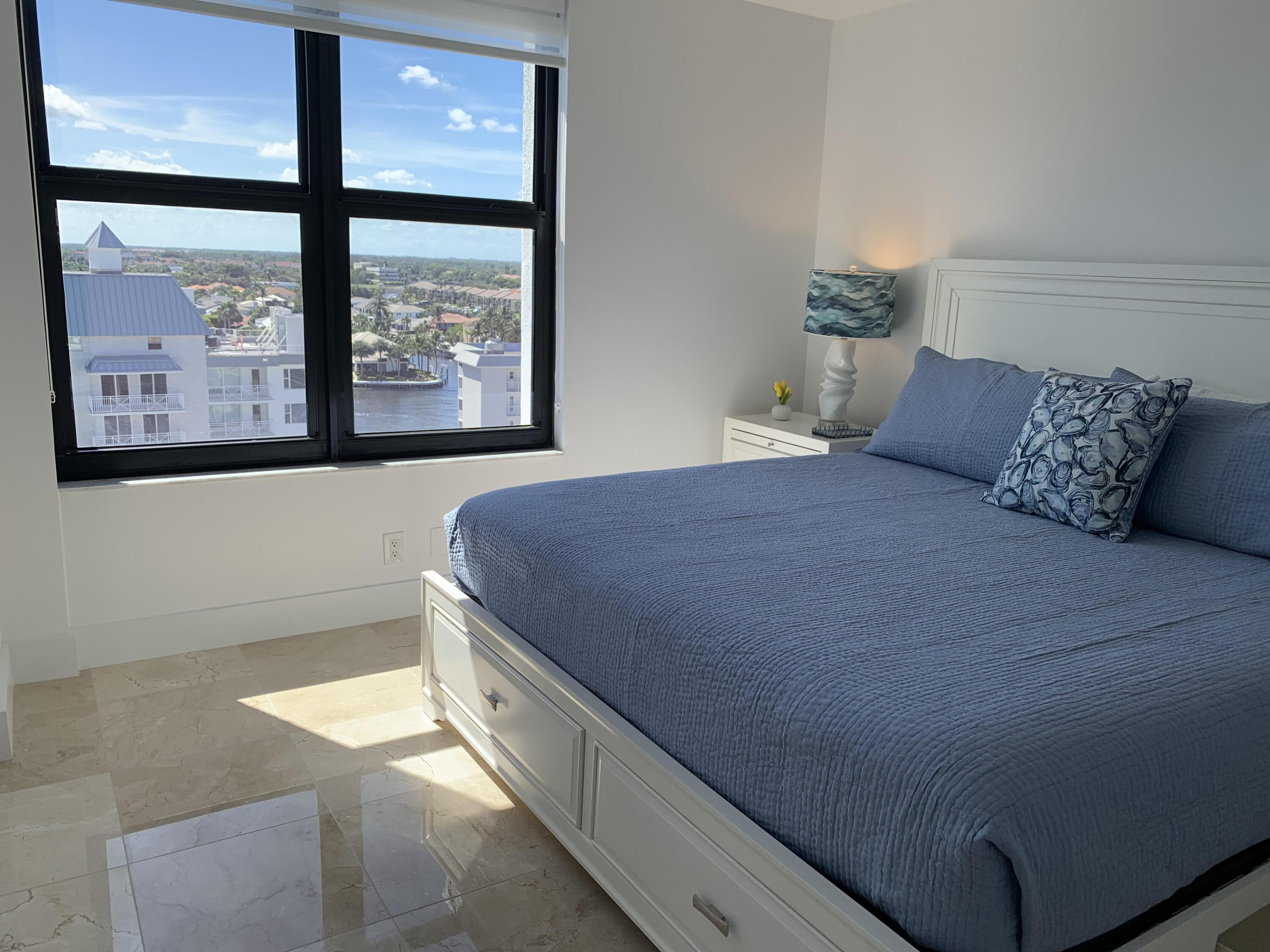 3115 South Ocean Boulevard, Unit 1002 Highland Beach, FL 33487 - Photo 16 of 37 a bed sitting in a bedroom next to a window