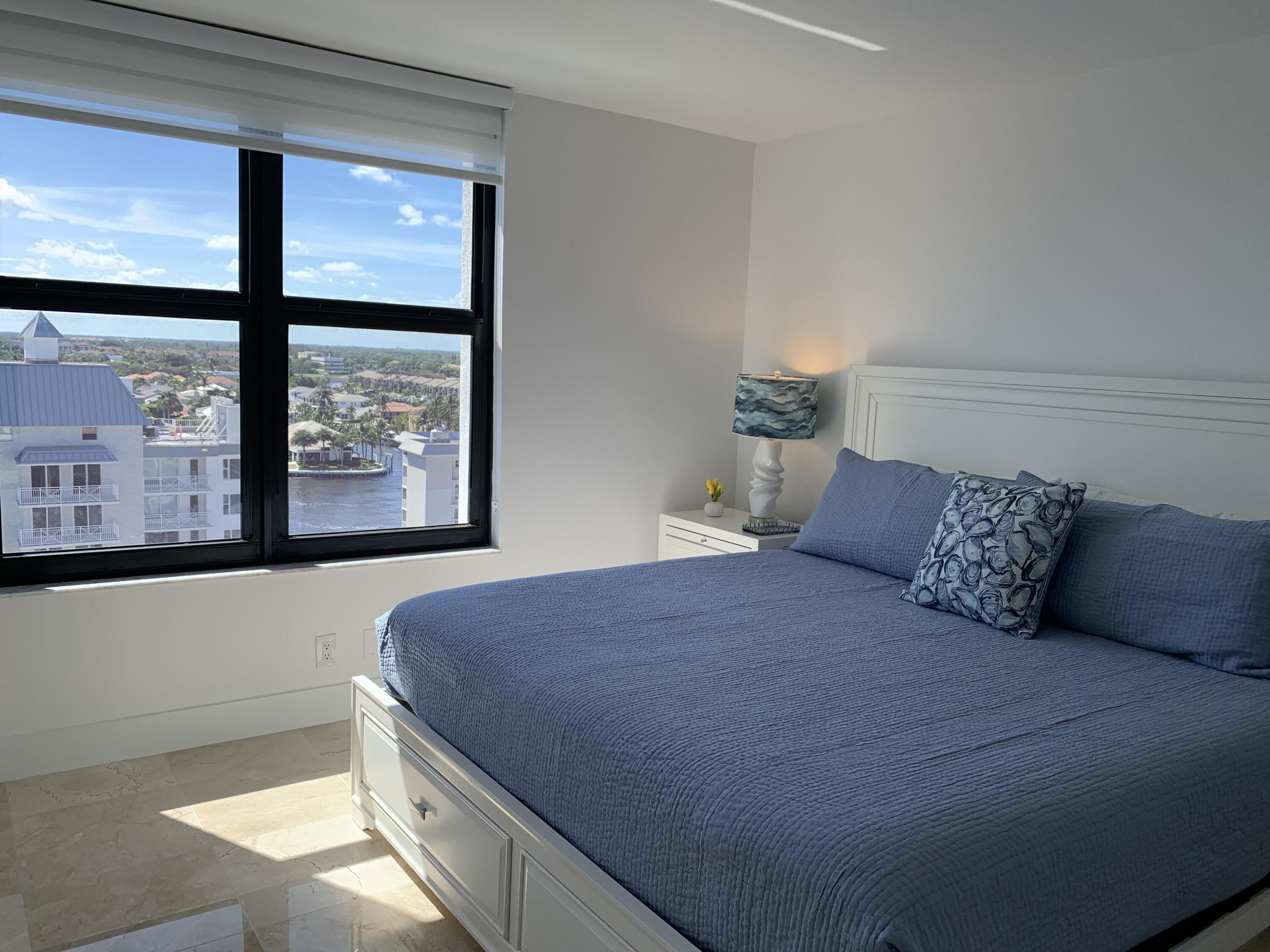 3115 South Ocean Boulevard, Unit 1002 Highland Beach, FL 33487 - Photo 17 of 37 a bedroom with a large bed and a large window