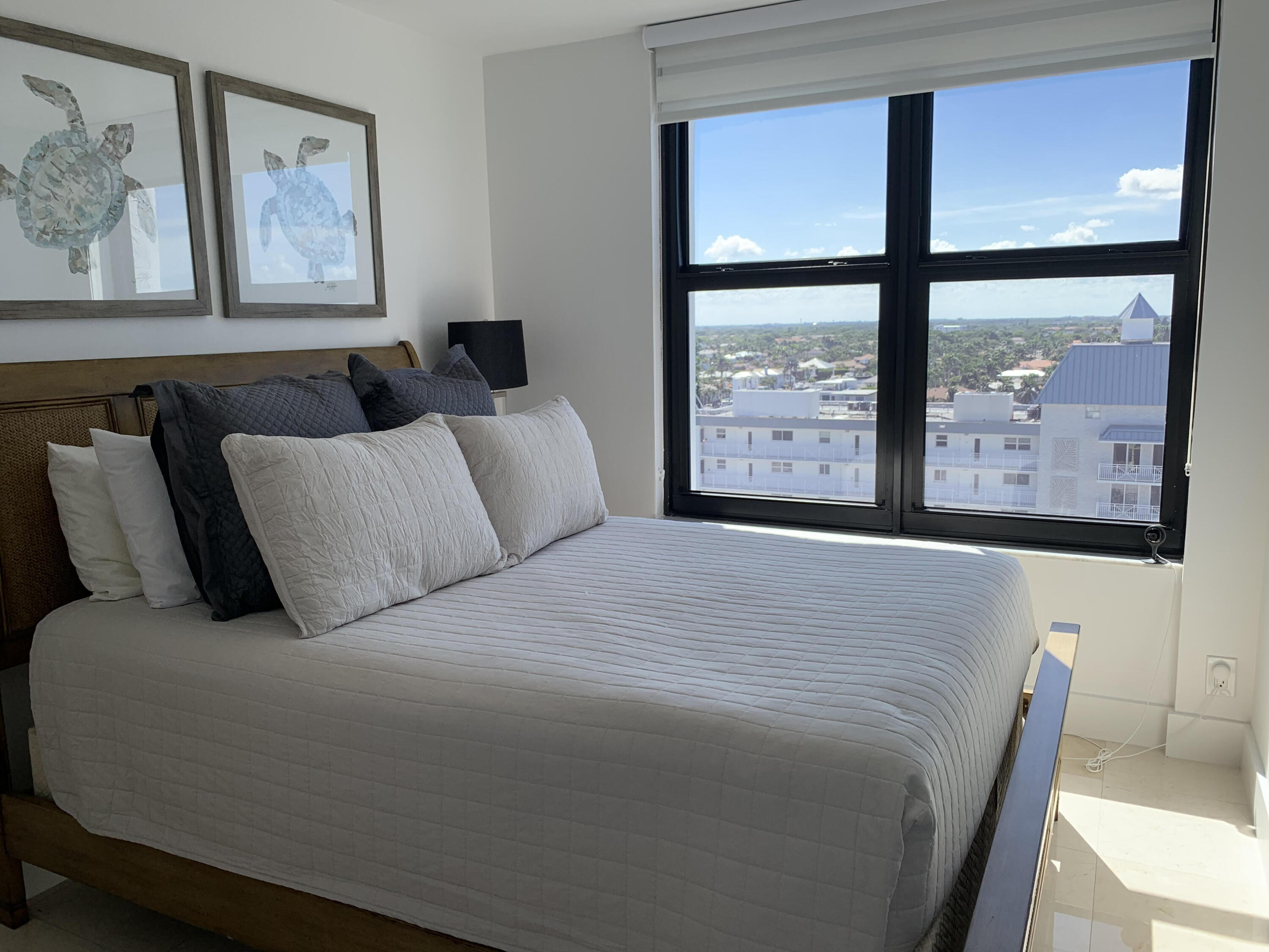 3115 South Ocean Boulevard, Unit 1002 Highland Beach, FL 33487 - Photo 19 of 37 a large bed sitting in a bedroom next to a window