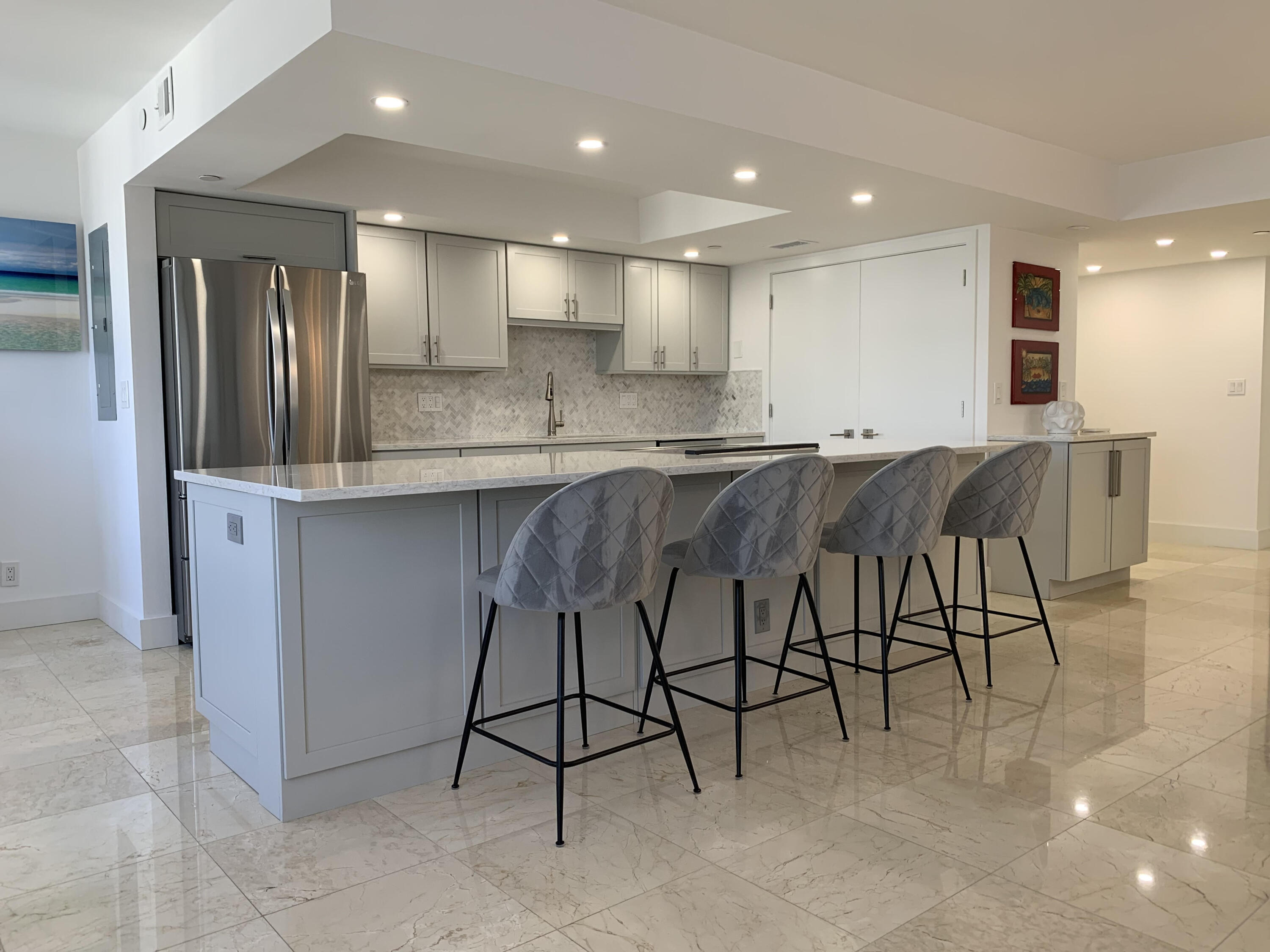 3115 South Ocean Boulevard, Unit 1002 Highland Beach, FL 33487 - Photo 4 of 37 a kitchen with kitchen island cabinets and chairs in it