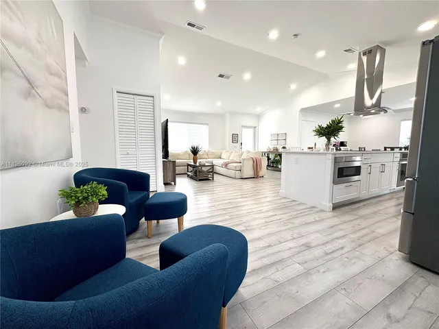 a living room with furniture kitchen view and a refrigerator