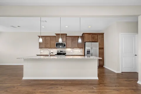 a kitchen with stainless steel appliances granite countertop a refrigerator a stove and a sink