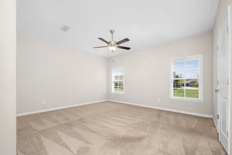 an empty room with a window and a ceiling fan