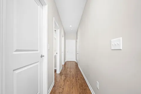 a view of a hallway with wooden floor and closet