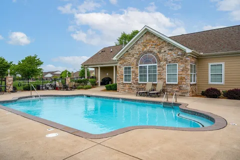a view of a house with pool lawn chairs and a table and chairs
