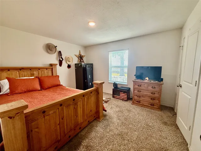 a bedroom with furniture and a flat screen tv