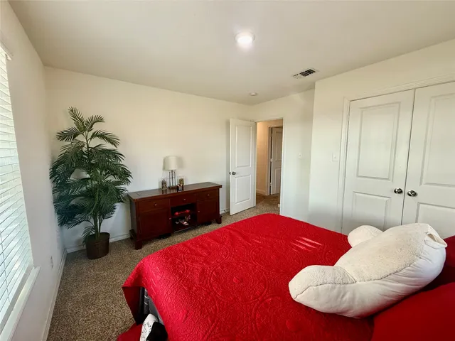 a bedroom with a bed and a potted plant