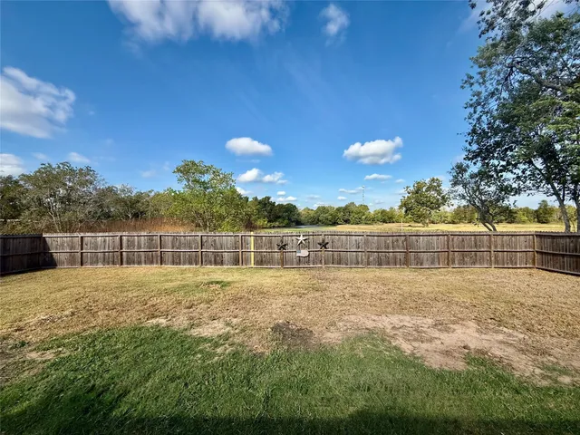 a view of a backyard with grass and a large tree