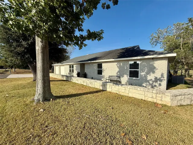 a view of a house with backyard and sitting area