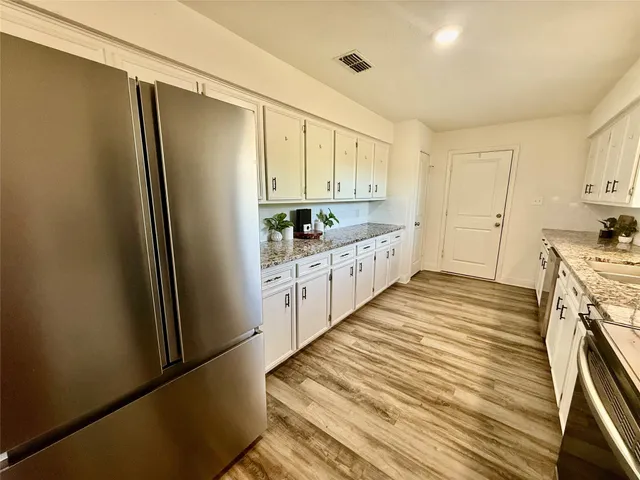 a kitchen with stainless steel appliances a refrigerator and cabinets