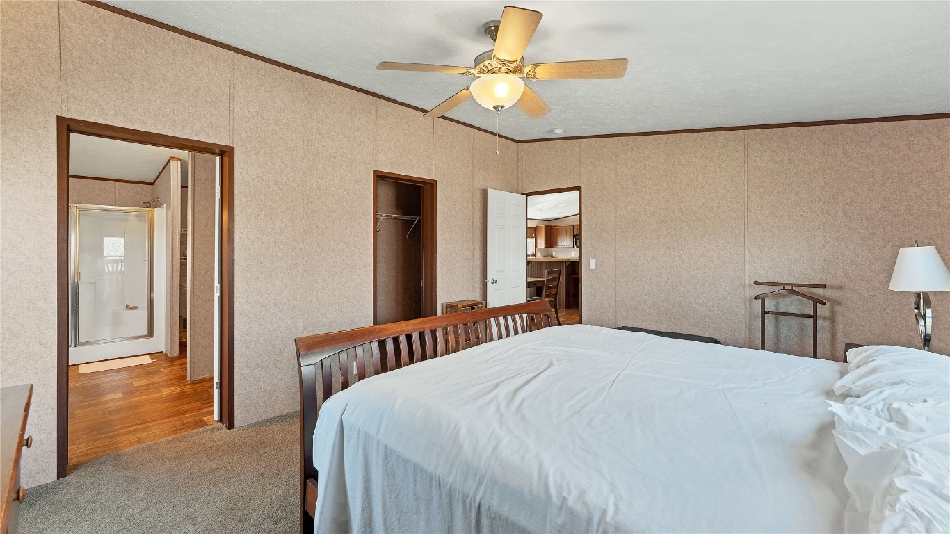 154 Cowboy Road Gonzales, TX 78629 - Photo 19 of 39 a bedroom with a bed and a chandelier