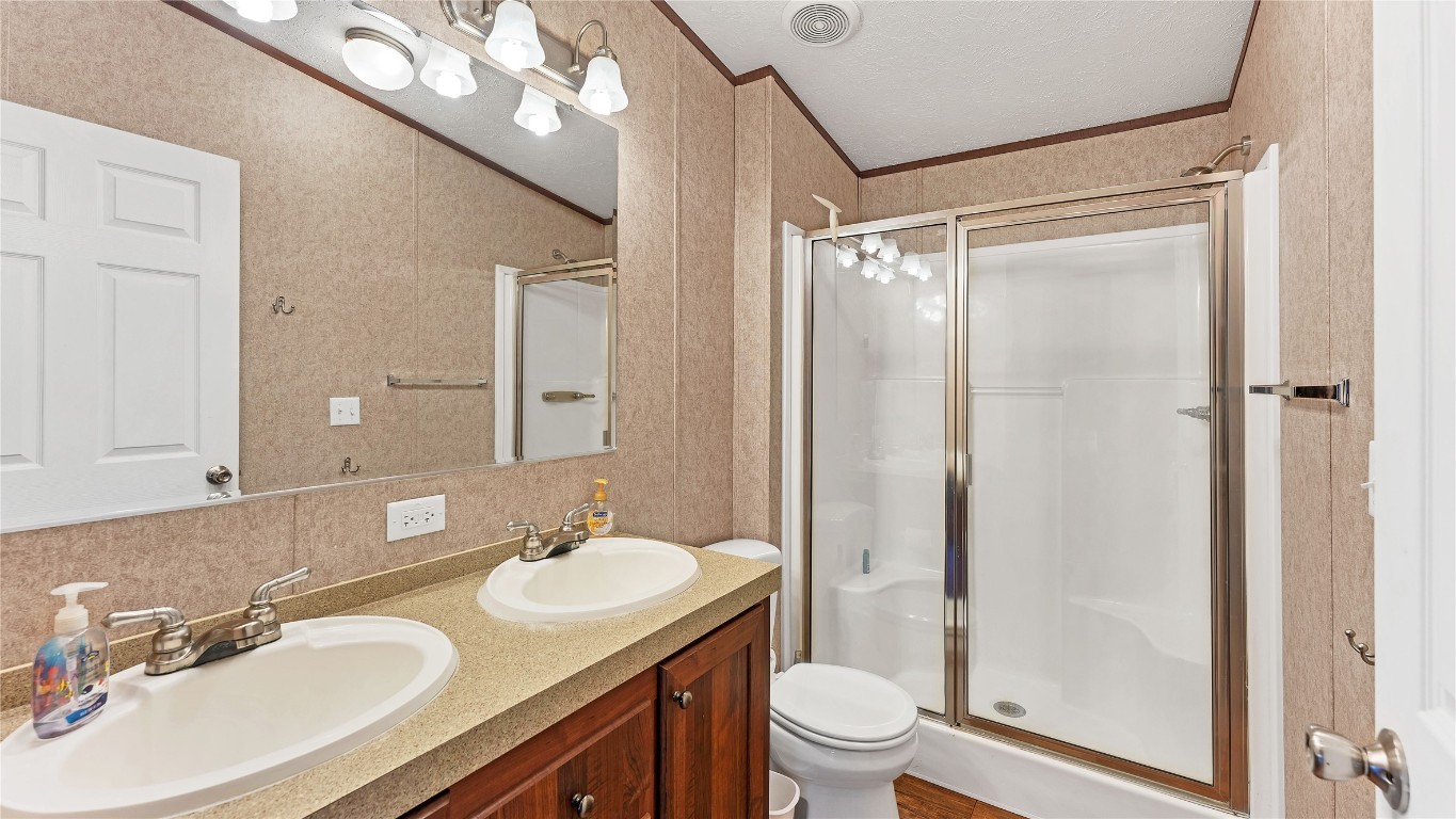 154 Cowboy Road Gonzales, TX 78629 - Photo 22 of 39 a bathroom with a double vanity sink toilet mirror and shower