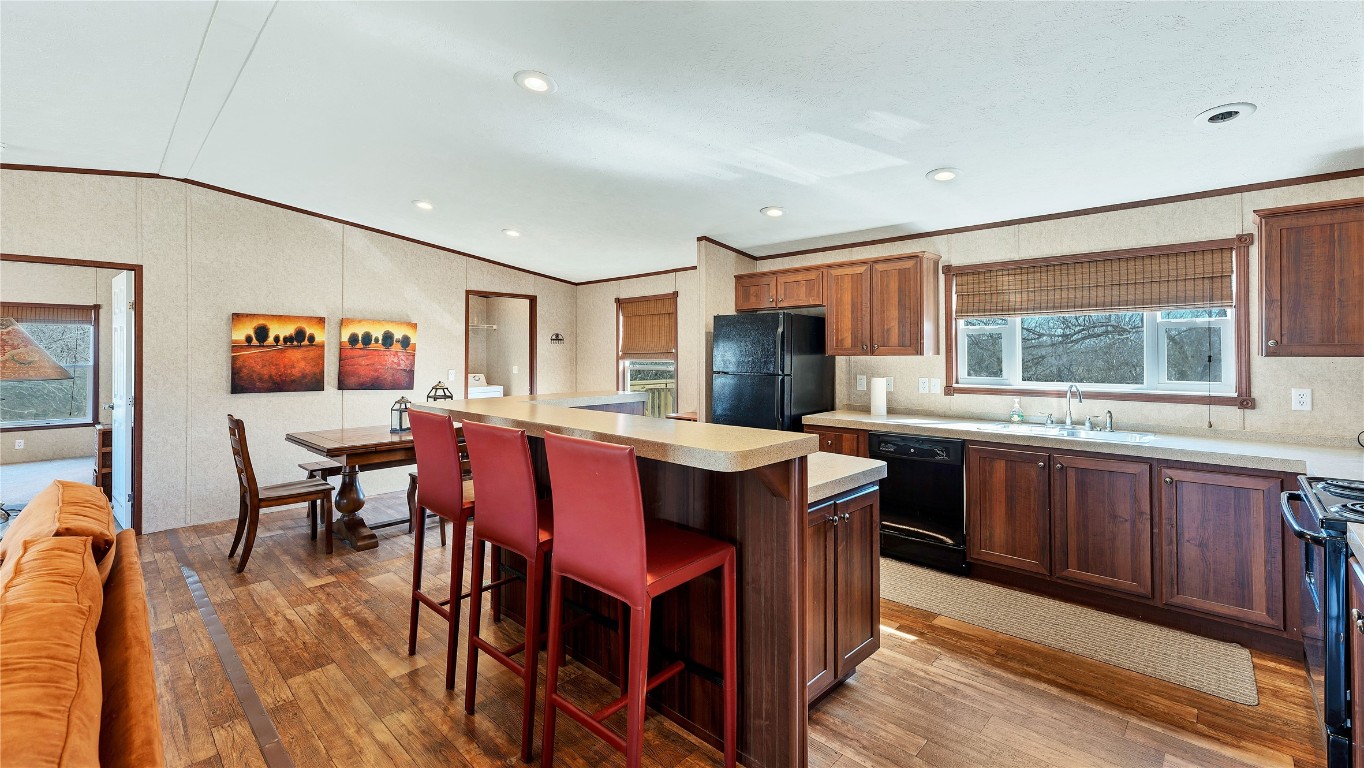 154 Cowboy Road Gonzales, TX 78629 - Photo 9 of 39 a kitchen with stainless steel appliances granite countertop a stove a refrigerator a sink a dining table and chairs with wooden floor