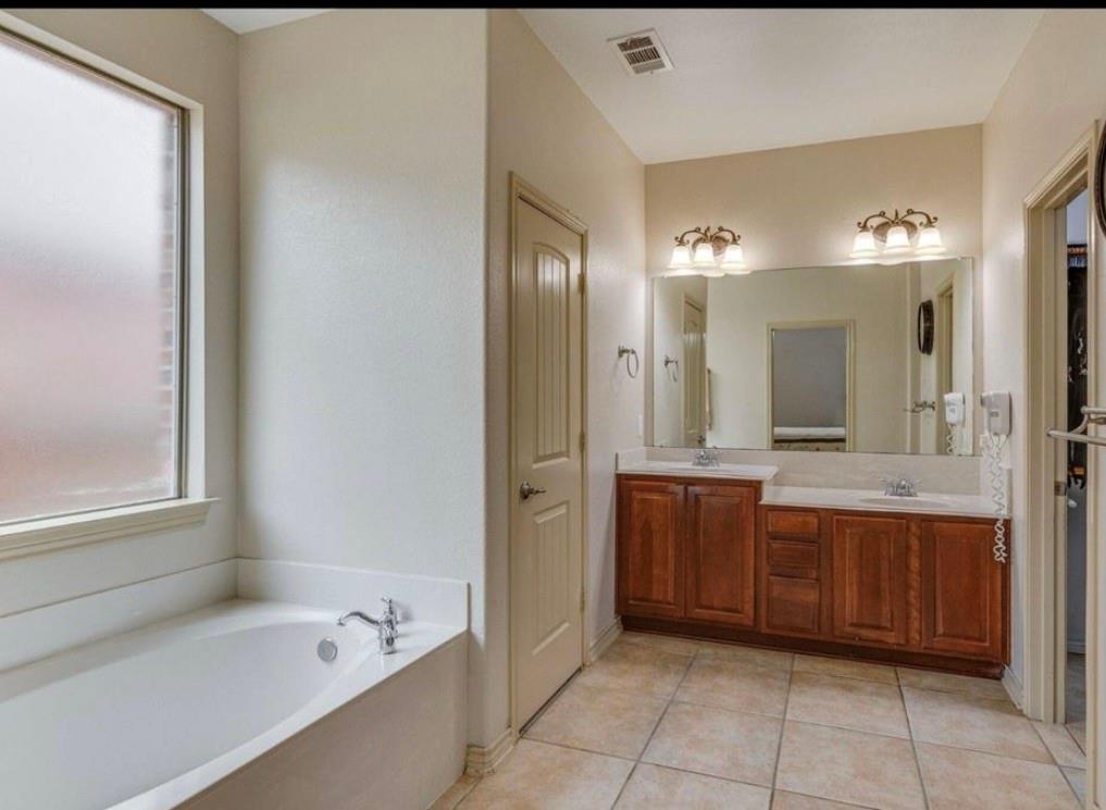 10001 Thurman Road Fort Worth, TX 76244 - Photo 13 of 18 a bathroom with a bathtub sink and mirror