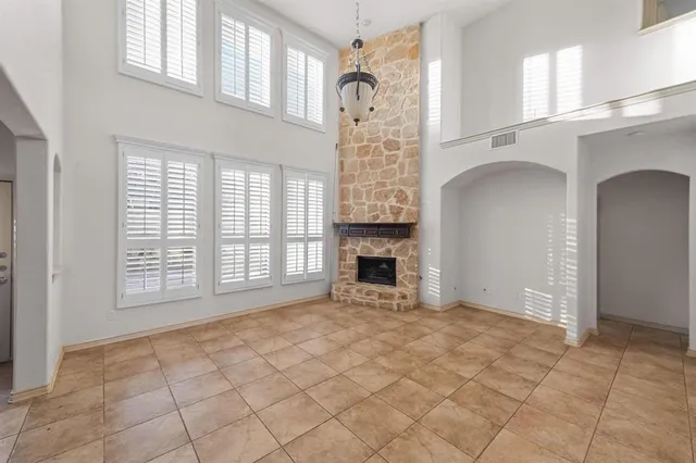 a view of an empty room with a fireplace and a window