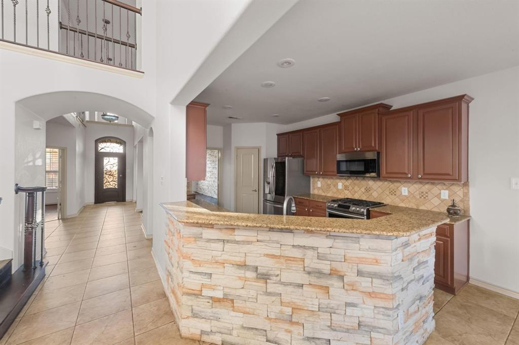 10001 Thurman Road Fort Worth, TX 76244 - Photo 5 of 18 a kitchen with stainless steel appliances granite countertop a stove a sink and a refrigerator