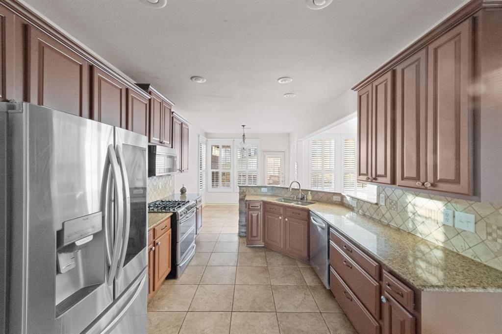 10001 Thurman Road Fort Worth, TX 76244 - Photo 9 of 18 a kitchen with stainless steel appliances granite countertop a refrigerator and a sink