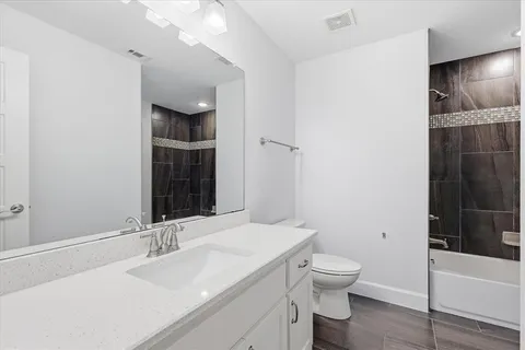 a bathroom with a granite countertop sink toilet and shower