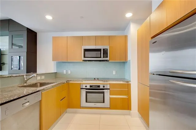 a kitchen with stainless steel appliances granite countertop a stove a microwave and a refrigerator