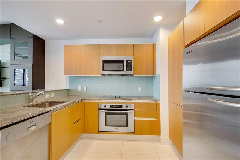 1050 Brickell Avenue, Unit 3222 Miami, FL 33131 - Photo 2 of 12 a kitchen with stainless steel appliances granite countertop a stove a microwave and a refrigerator