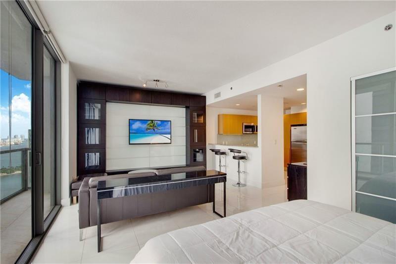 1050 Brickell Avenue, Unit 3222 Miami, FL 33131 - Photo 7 of 12 a living room with furniture and a flat screen tv