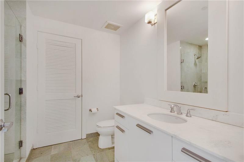 1050 Brickell Avenue, Unit 3222 Miami, FL 33131 - Photo 10 of 12 a bathroom with a sink and a mirror