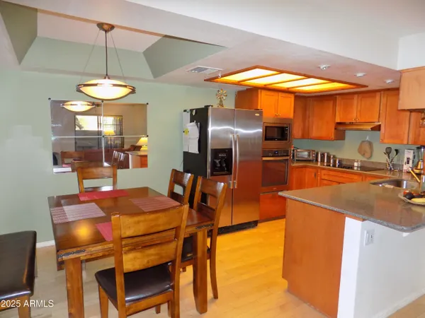 a kitchen with stainless steel appliances granite countertop a sink a stove and a refrigerator