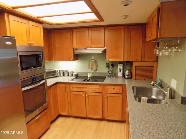 a kitchen with granite countertop a sink and a stove top oven