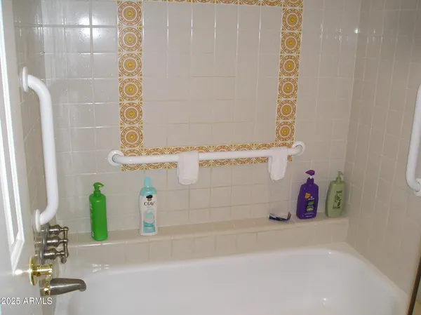 a bathroom with a tub shower and a sink