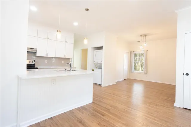 a large kitchen with kitchen island a sink wooden floor and a refrigerator