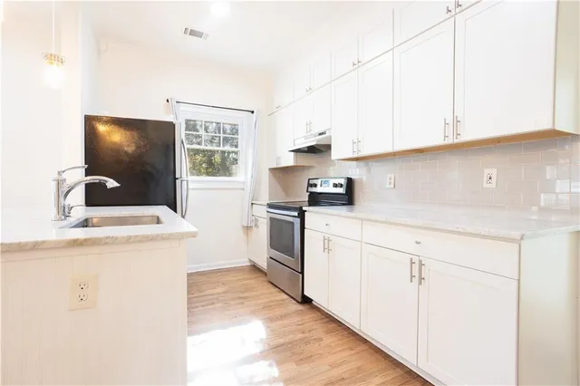 a kitchen with granite countertop white cabinets and white appliances