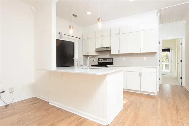 a kitchen with kitchen island a stove a sink and a refrigerator