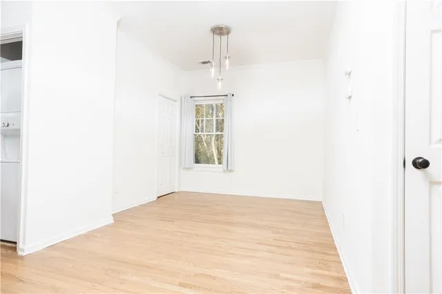 a view of a hallway with wooden floor and a window