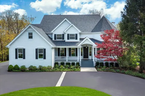 a front view of a house with a yard and potted plants