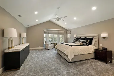 a large white kitchen with granite countertop wooden floor sink and cabinets