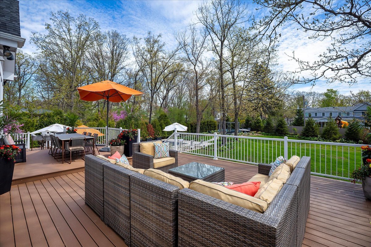 1423 Northwoods Road Deerfield, IL 60015 - Photo 29 of 39 a view of a patio with couches table and chairs under an umbrella with wooden floor